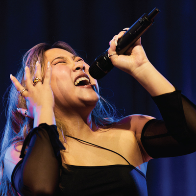 Close-up of a female a cappella singer performing with high energy.